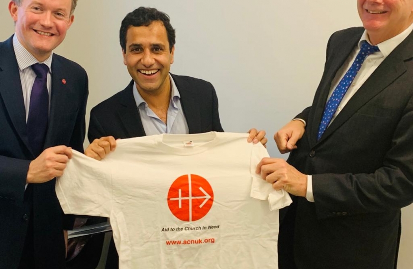 Rehman holding t-shirt with Aid to the Church in Need