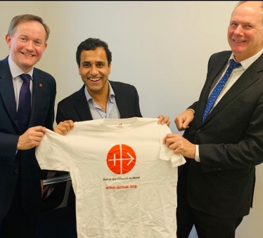 Rehman holding t-shirt with Aid to the Church in Need