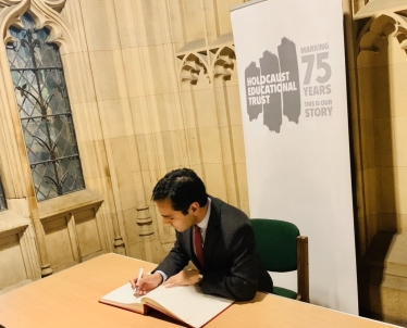 Rehman signing the Book of Commitment