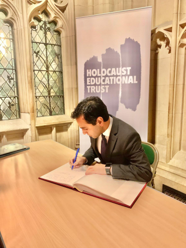 Rehman signing the Holocaust memorial book 2023